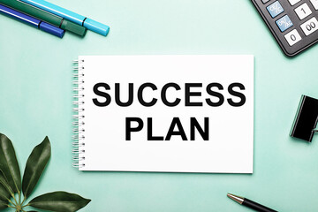 SUCCESS PLAN is written on a white sheet on a blue background near the stationery and the Scheffler sheet. Call to action. Motivational concept