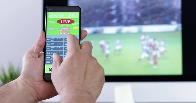 man playing gamble on football bet application at smartphone