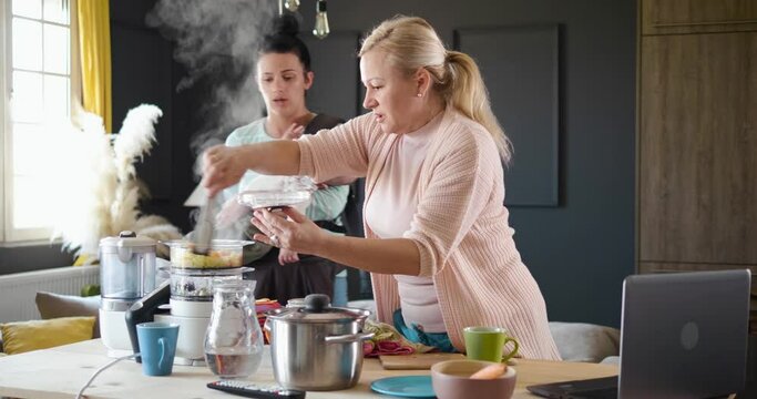 Grandma and daughter in the kitchen preparing food steam cooker.