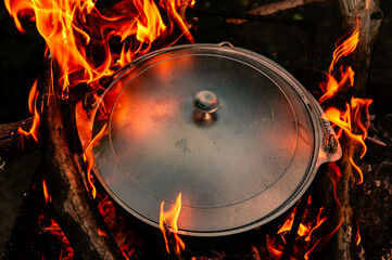 Outdoor cooking with a cast iron pot on a open fire
