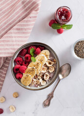 porridge with raspberries banana and nuts on coconut milk