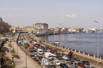 Kyiv, Ukraine- April 1, 2021: Automobile collapse at the highway along Dnipro River. Traffic jam with rows of cars on motorway in the week-end day in Kyiv. Concept of traffic jams in the big city.