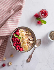 porridge with raspberries banana and nuts on coconut milk