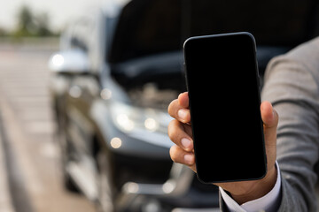 Blank screen of smartphone. Young businessman holding smartphone using application to call service and help car was broken down.