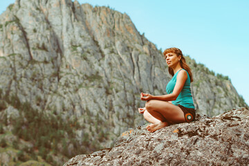 Fototapeta na wymiar a girl meditates in the mountains