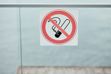 No smoking sign on a glass background on the background of water on the street