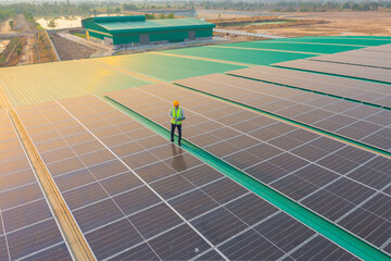 Aerial top view of engineer man or worker,people, with solar panels or solar cells on the roof in factory industry. Power plant, renewable energy source. Eco technology for electric power. Maintenance