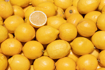 Bright solid fruit background of yellow lemons