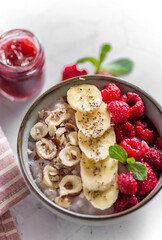 porridge with raspberries banana and nuts on coconut milk