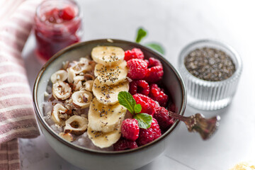 porridge with raspberries banana and nuts on coconut milk