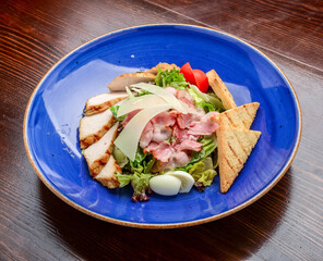 Chicken Caesar Salad. Caesar Salad with grilled chicken on plate. Grilled chicken breasts and fresh salad in plate