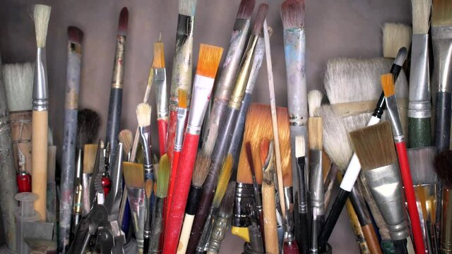 An assortment of artist's tools ; brushes and pens of varied construction, palette knives, etc