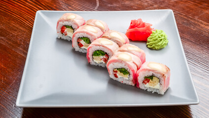 Salmon, tuna, sushi rolls set. On wooden background