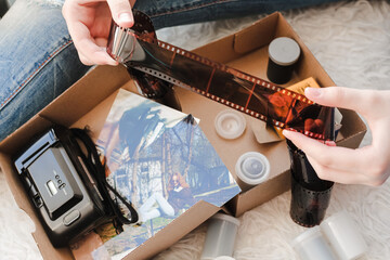 Old photo holding by a teenage girl, retro background with vintage camera, photos and film negative.