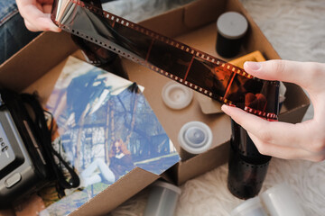 Old photo holding by a teenage girl, retro background with vintage camera, photos and film negative.