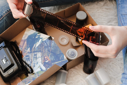 Old photo holding by a teenage girl, retro background with vintage camera, photos and film negative.