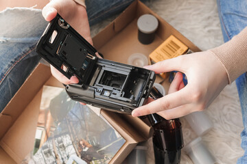 Old photo holding by a teenage girl, retro background with vintage camera, photos and film negative.