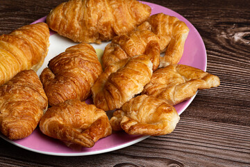 Croissants en plato sobre fondo de madera.