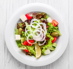 Fresh Greek salad in a bowl, top view