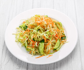 Fresh vegetable salad with cabbage, carrot, green onion and cucumber