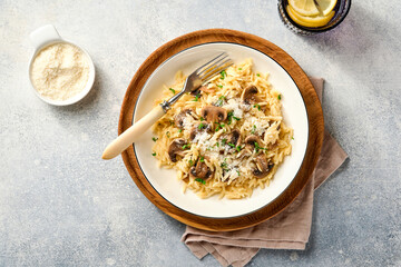 Dining italian pasta risoni, mushrooms, sauce, Parmesan, thyme, garlic, olive oil, in white plate...