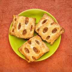 danish strudel bite with apple flavour, top view of a plate against textured handmade paper