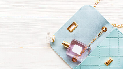 Fashion blue bag woman accessories set. Trendy blue fashion with perfume on wood white background....