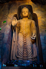 Large stone statue of Buddha in a cave in Wat Saket Golden Mountain Temple famous Landmark in Bangkok, Thailand.
