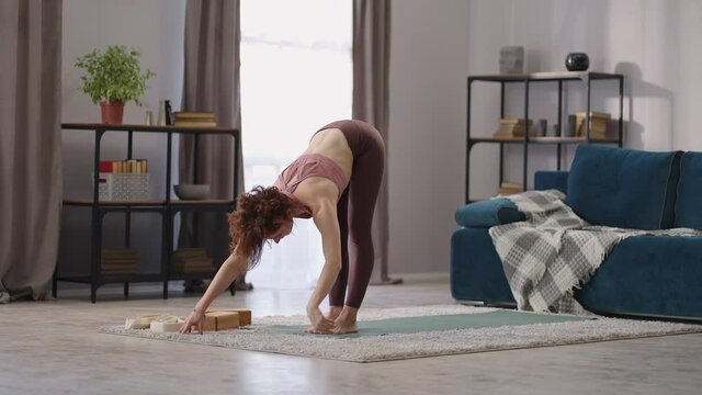 workout in living room, home fitness of housewife, lady is performing physical exercises standing alone in living room
