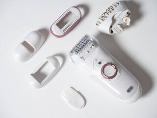 electric female epilator with a set of attachments on a white background. Modern devices for...