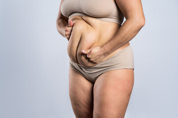 Tummy tuck, flabby skin on a fat belly, plastic surgery concept