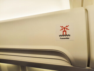 Sign of transmitter on aircraft overhead bin.