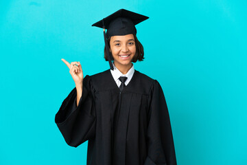 Young university graduate girl over isolated blue background pointing finger to the side