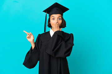 Young university graduate girl over isolated blue background with surprise expression while pointing side