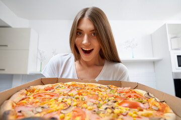 Smiling woman holding delicious pizza.