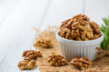 Walnut in white cup on wood background. healthy nuts concept. atherosclerosis.