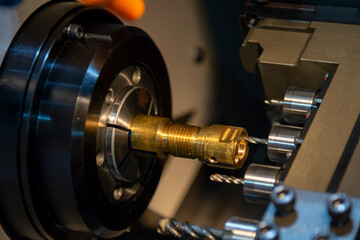 Naklejka premium The operation of multi-tasking CNC lathe machine swiss type cutting the hi-precision part. The hi-technology pipe connector parts by CNC turning machine.