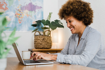 Senior african woman using laptop computer at home office - Mature woman working at home office - Focus on face