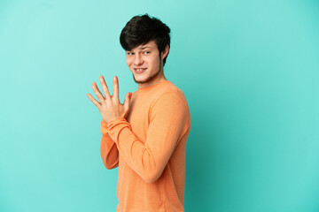 Young Russian man isolated on blue background scheming something