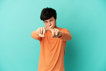 Fototapeta premium Young Russian man isolated on blue background making stop gesture with her hand to stop an act