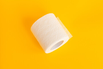 white toilet paper on a bright isolated yellow background. Photo
