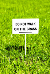 Notice board on the lawn with text "Do not walk on the grass"