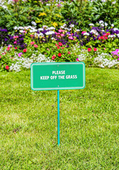 Notice board on the lawn with text "Please keep of the grass"