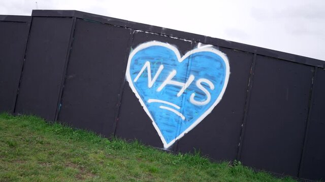 Street art and graffiti of a blue heart for the NHS in London United Kingdom, support to the national health service during Covid-19 Coronavirus pandemic, on a cloudy day