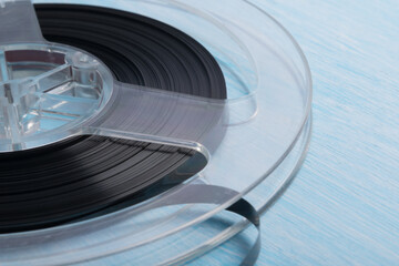 close-up of a reel with magnetic tape for recording music, retro version, on a blue background