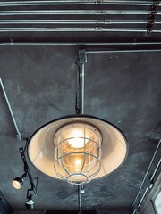 Interiors - Rustic and vintage hanging lamp on the wooden ceiling in cafe, bar and restaurant