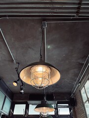 Interiors - Rustic and vintage hanging lamp on the wooden ceiling in cafe, bar and restaurant