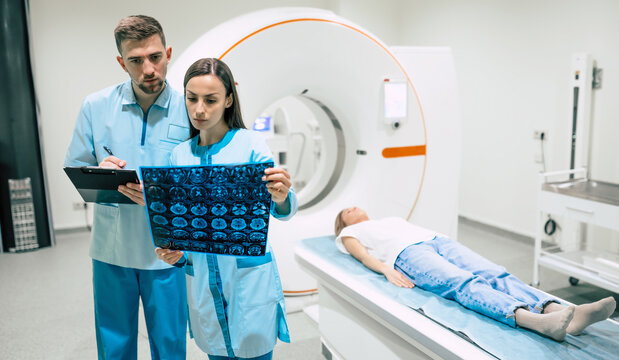 Confident experienced professional oncologist looking at the magnetic resonance imaging scan results of the human brain