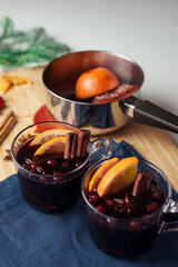 Hot red mulled wine with orange and spices in a saucepan. Christmas celebration.