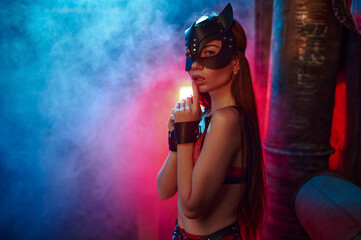 Sexy woman poses in bdsm suit and leather cat mask - obrazy, fototapety, plakaty